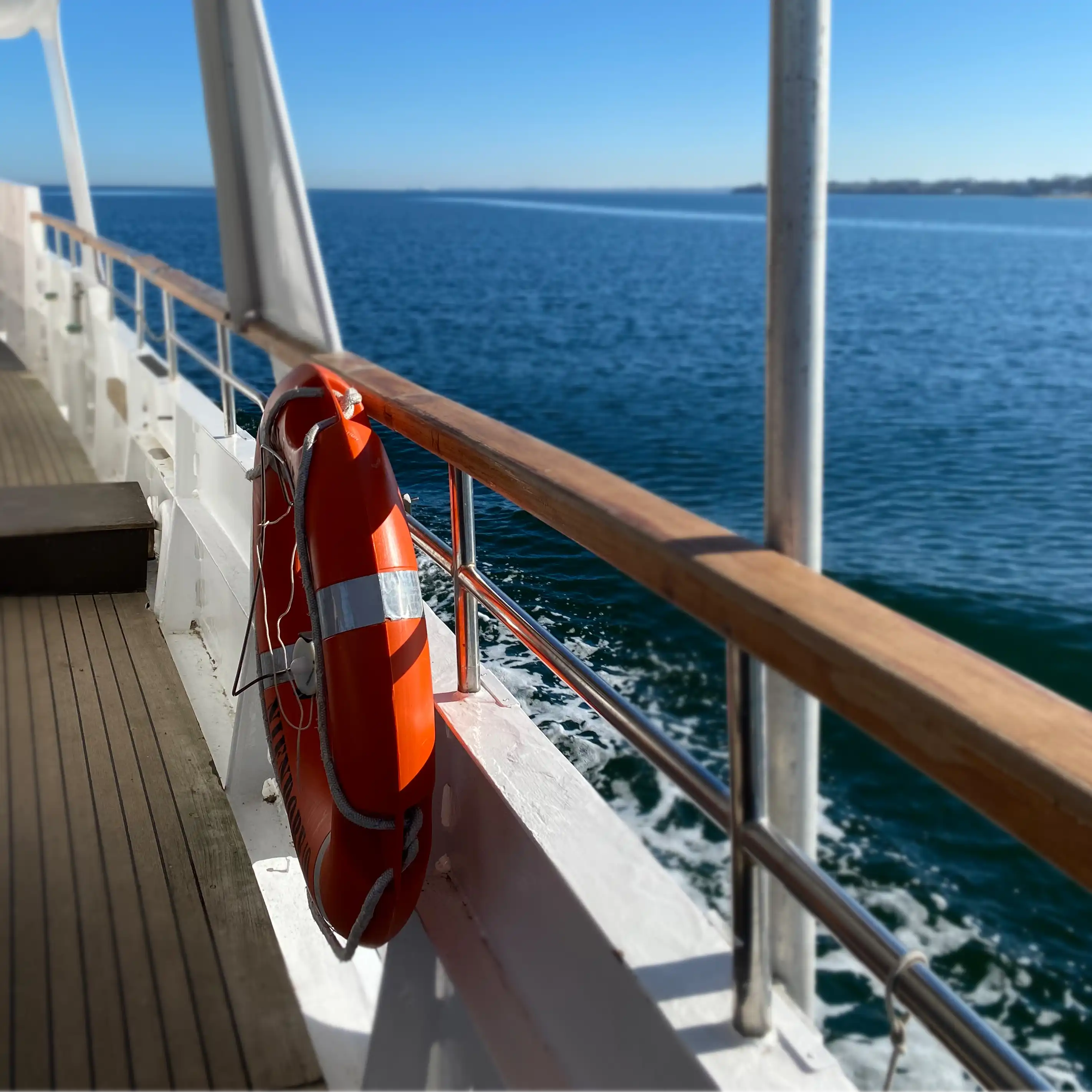 Auf hoher See mit einem Boot, im Vordergrund ein Rettungsring